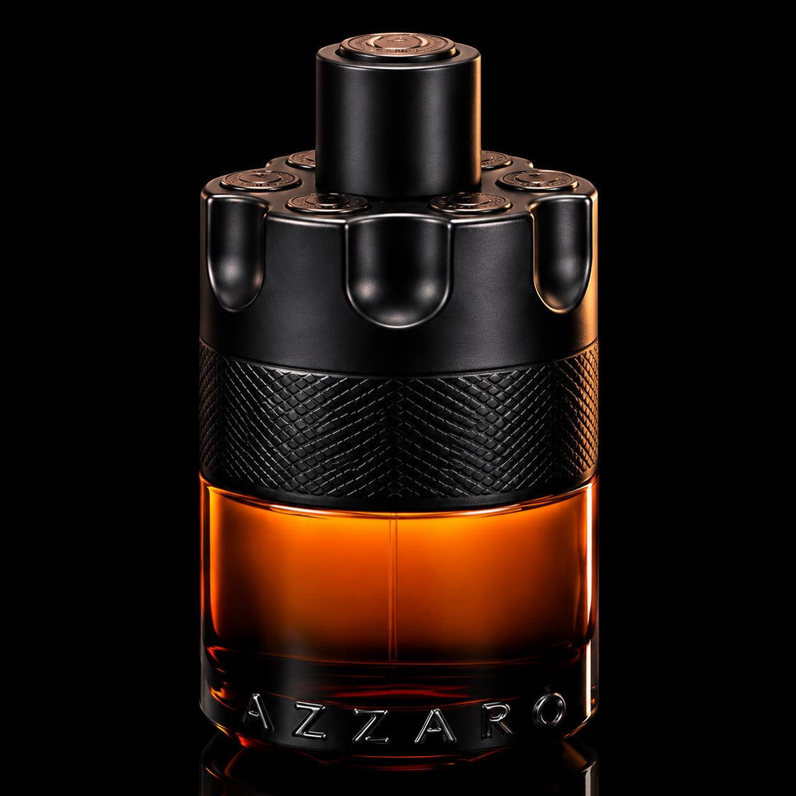 decantME Azzaro The Most Wanted Parfum in a revolver-style glass bottle with amber liquid on a black background